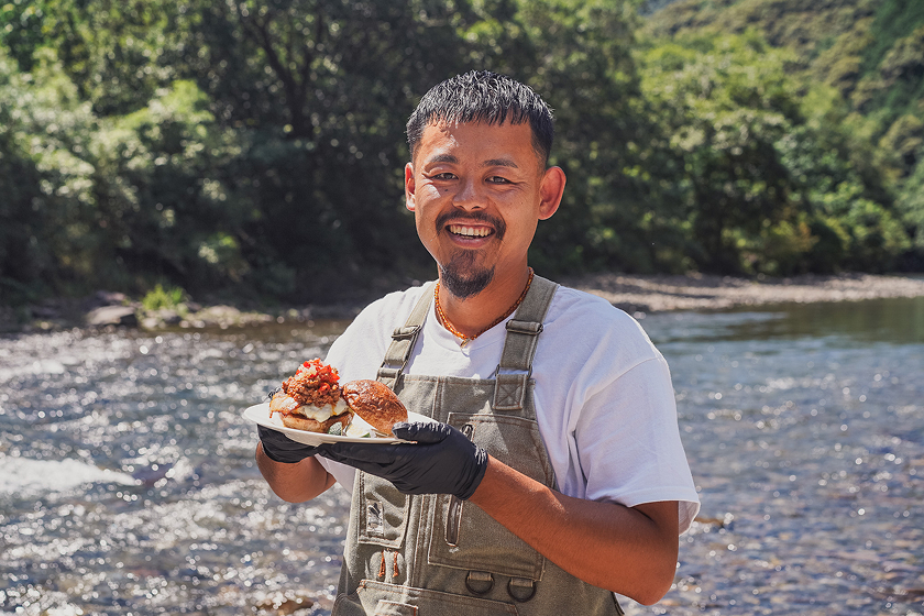 四万十川を背景に笑顔の松本さんは地域おこし協力隊として活動して3年目を迎える