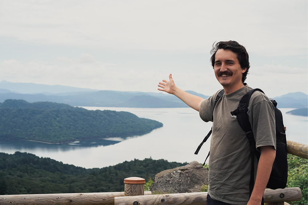 北海道北見市の屈斜路湖を背景に地域資源を記録し情報発信を行う外国人地域おこし協力隊の活動