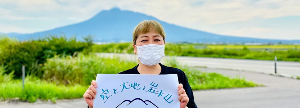 雄大な岩木山を背景にご機嫌な笠原さん